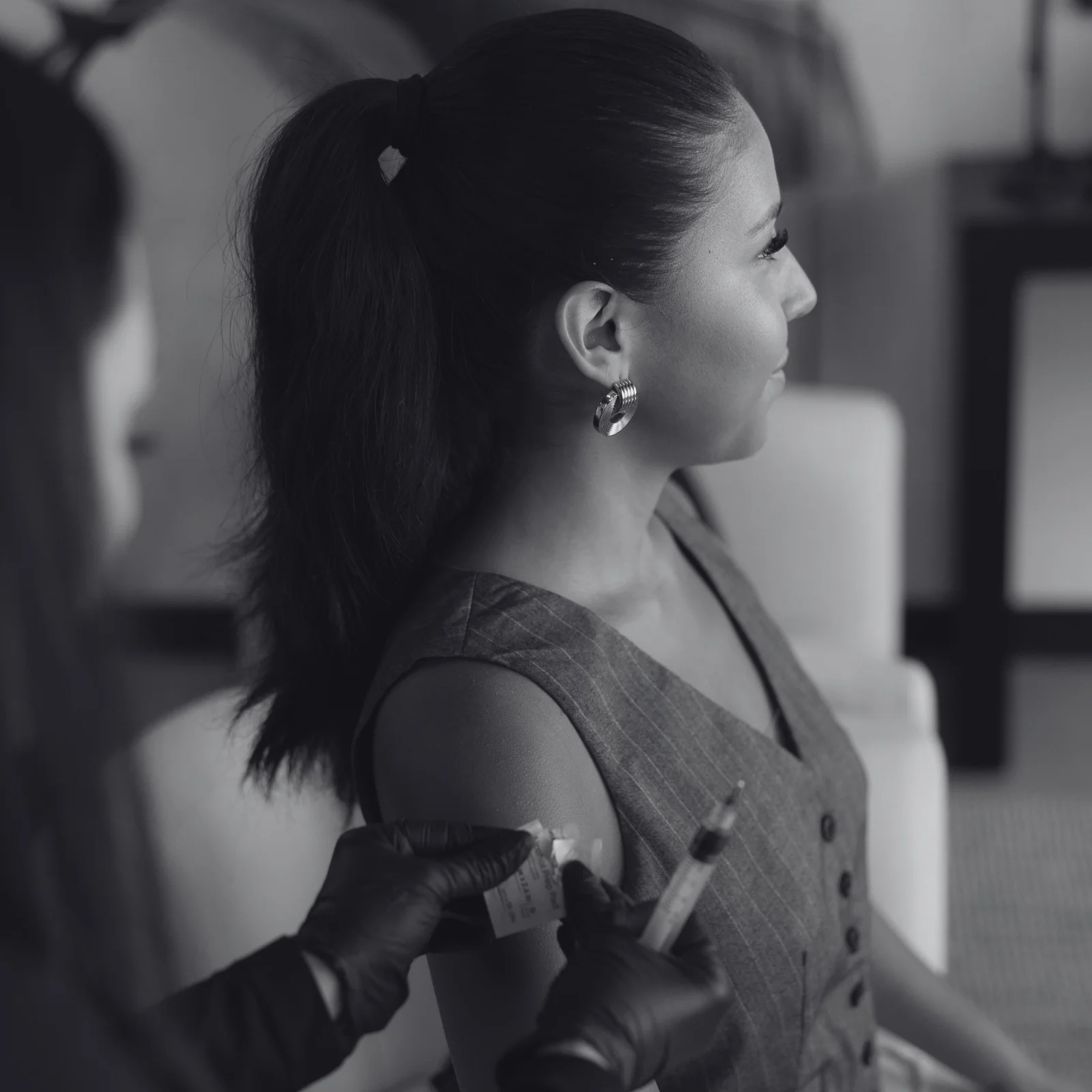 A woman sitting down with a pair of gloves on.