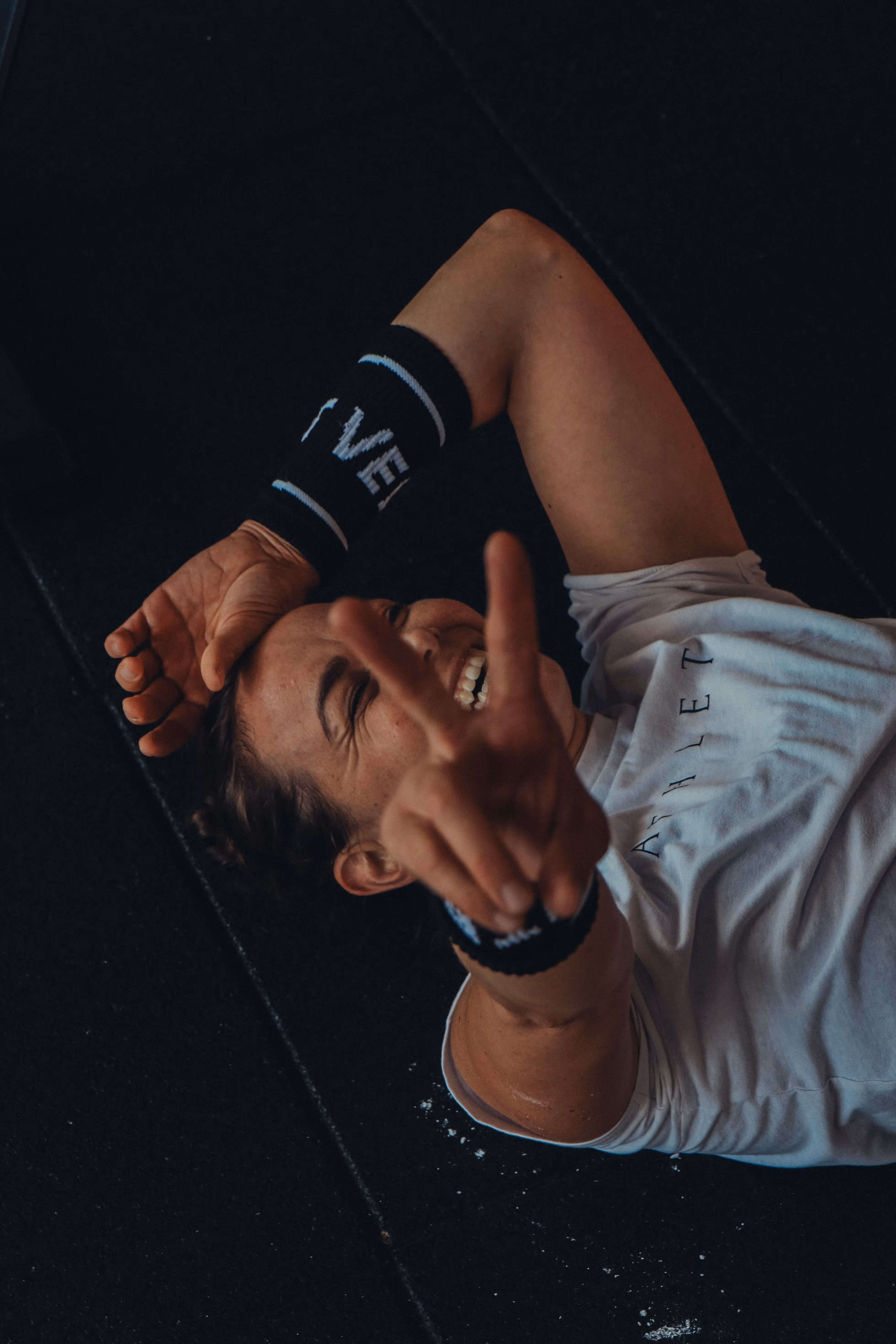 Frau liegt lachend und erschöpft am Boden