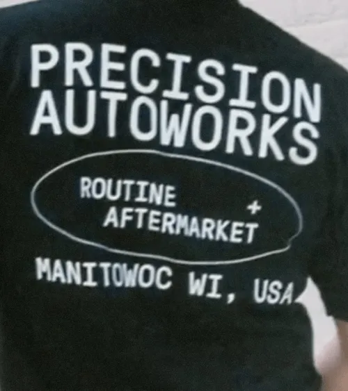 Black shirt with white text reading 'PRECISION AUTOWORKS', 'ROUTINE + AFTERMARKET' circled in the center, and 'MANITOWOC WI, USA' at the bottom.