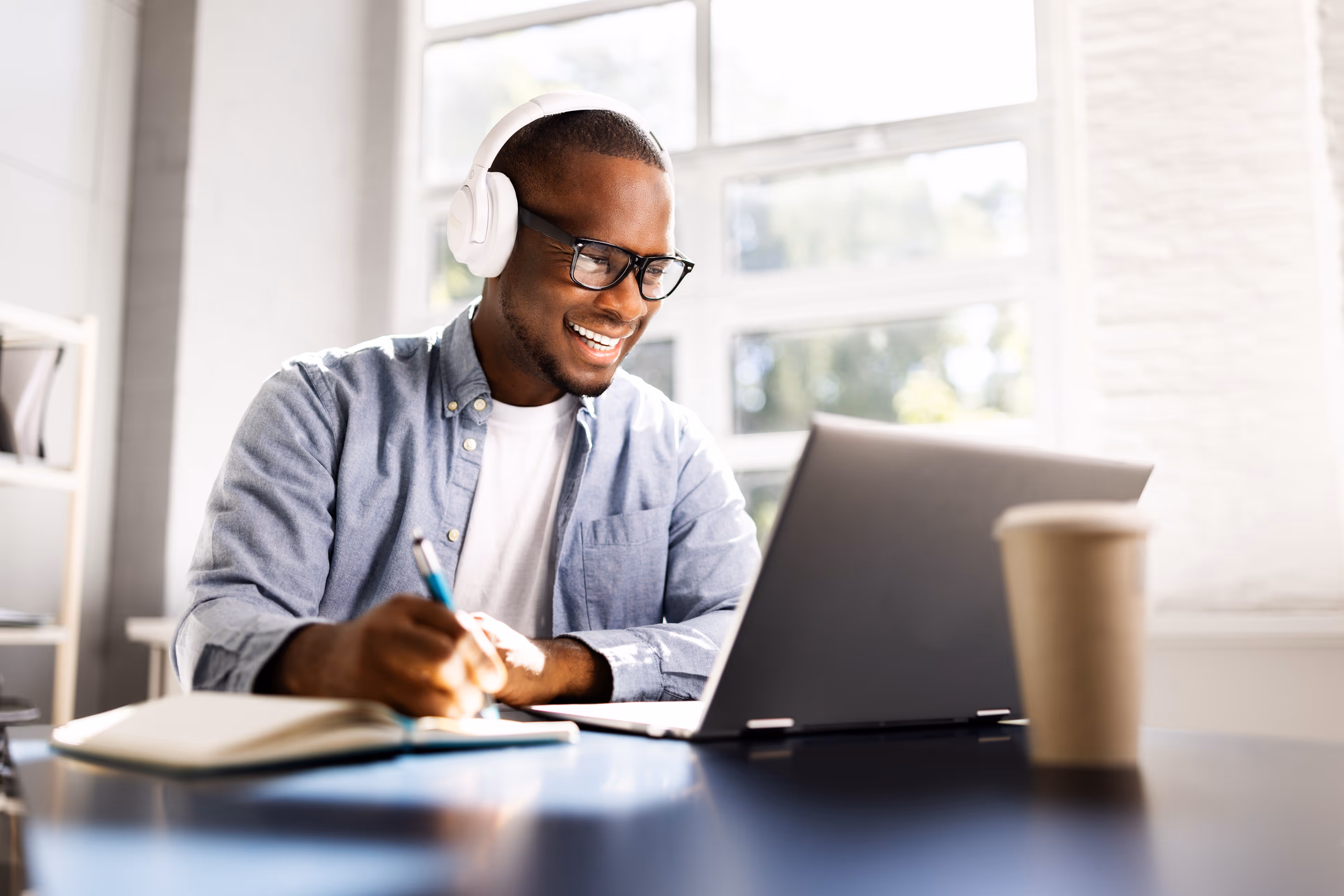 Young person sitting at a laptop with headphones, viewing on-demand CPD and CEU workshops.