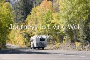 A camper drives along a scenic road surrounded by colorful autumn trees.