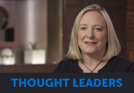 A woman with shoulder-length blonde hair speaks in a professional setting about health technology.