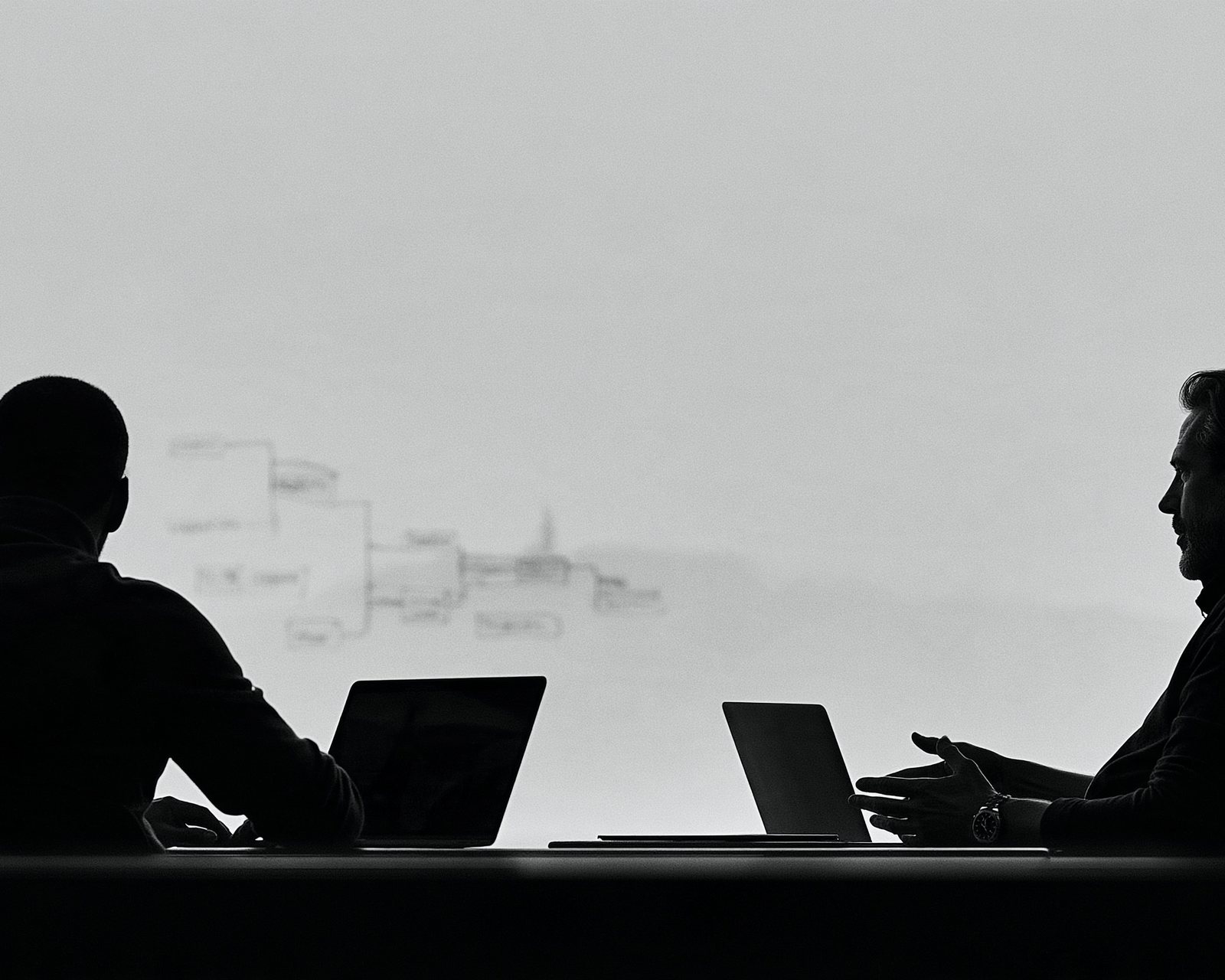 People moving through an open-plan office, fog outside the tall windows.