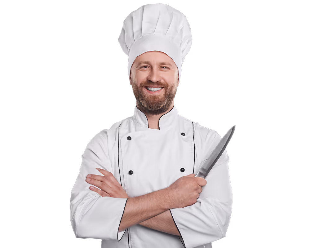 Smiling bearded male chef in white uniform and hat holding a kitchen knife with crossed arms.
