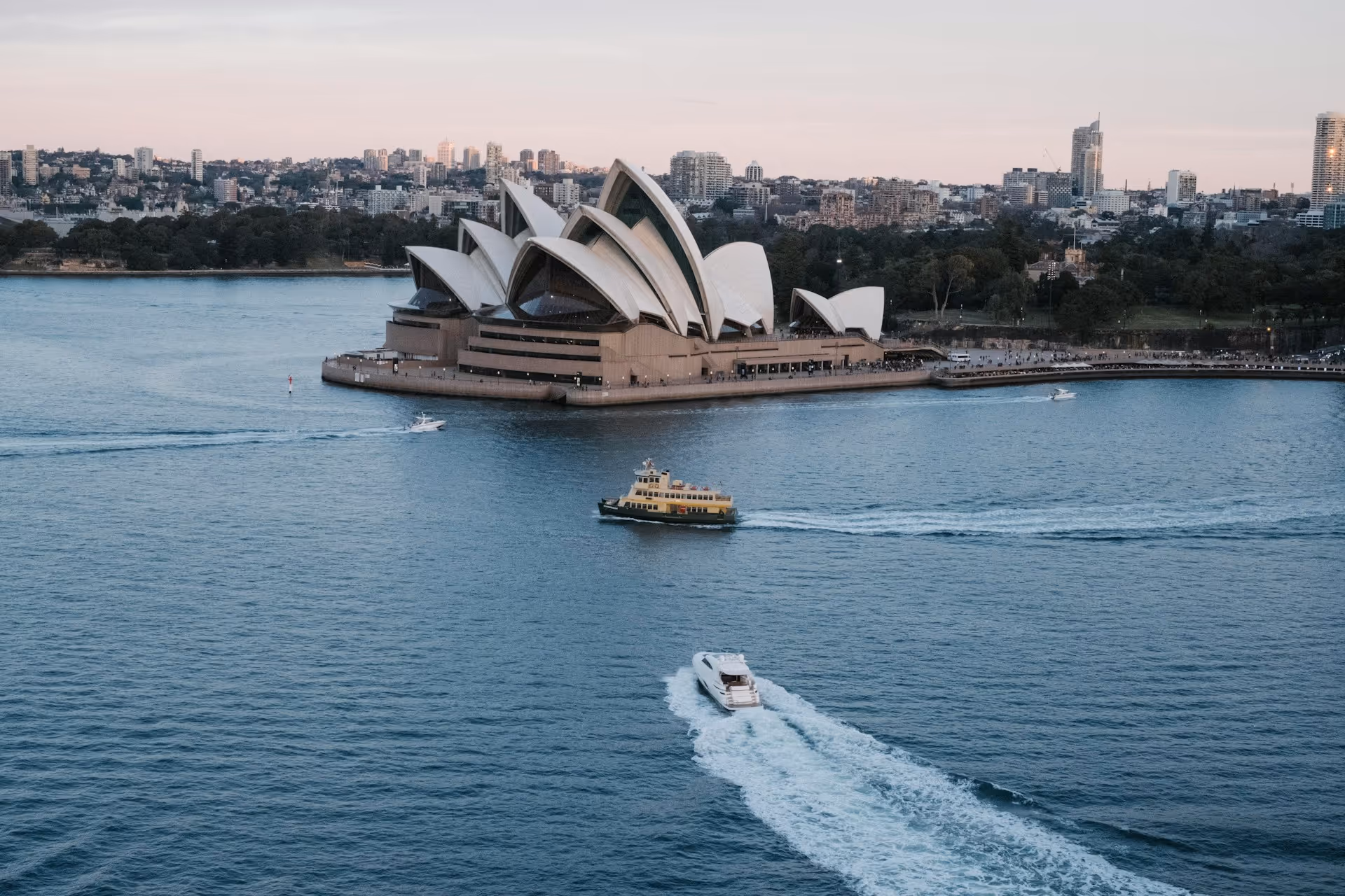 Sydney Opera House overlooking Sydney Harbour with ferries and boats moving across the water