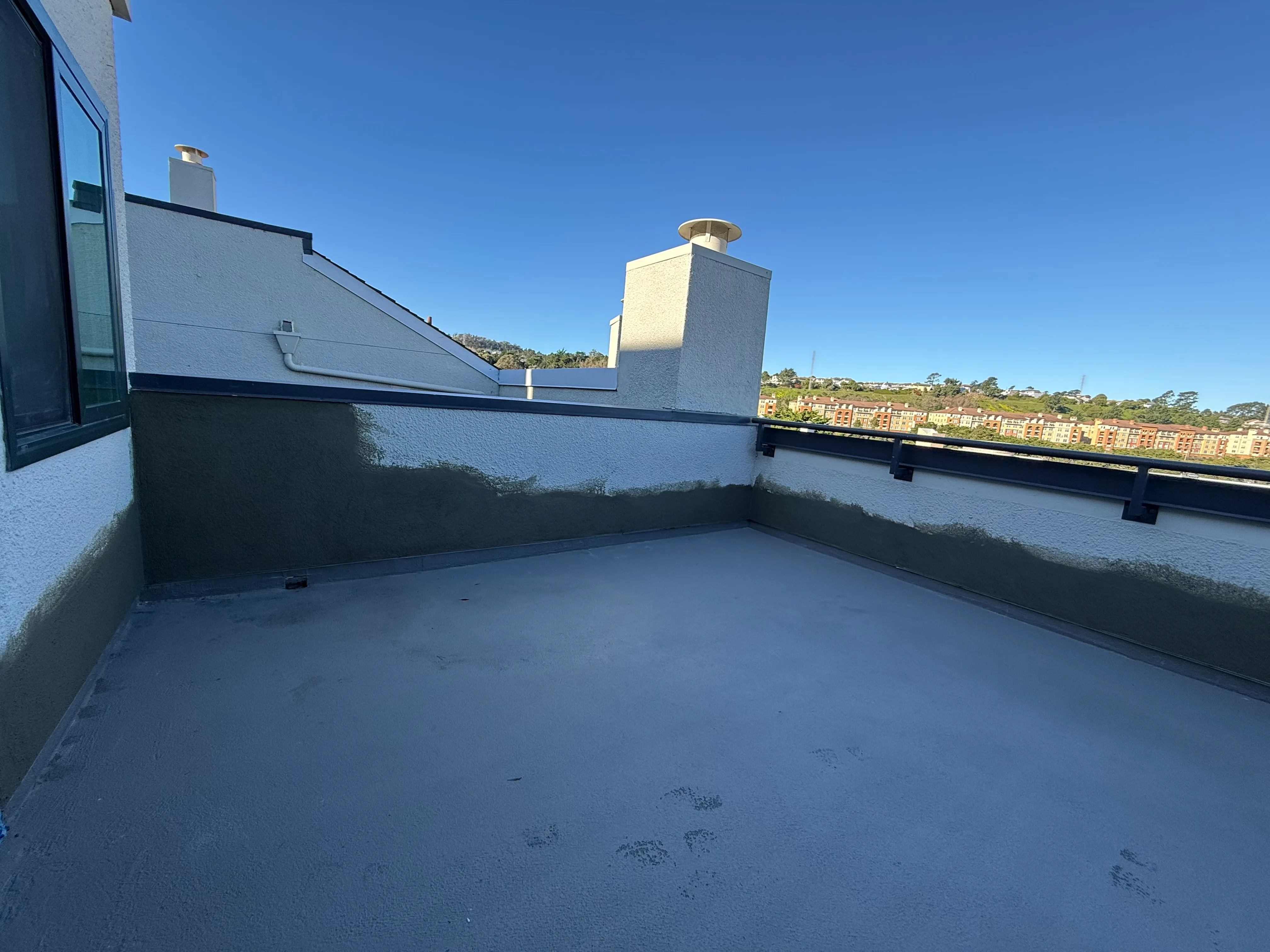 Exterior balcony waterproofing with coating system applied to deck surface and parapet walls.