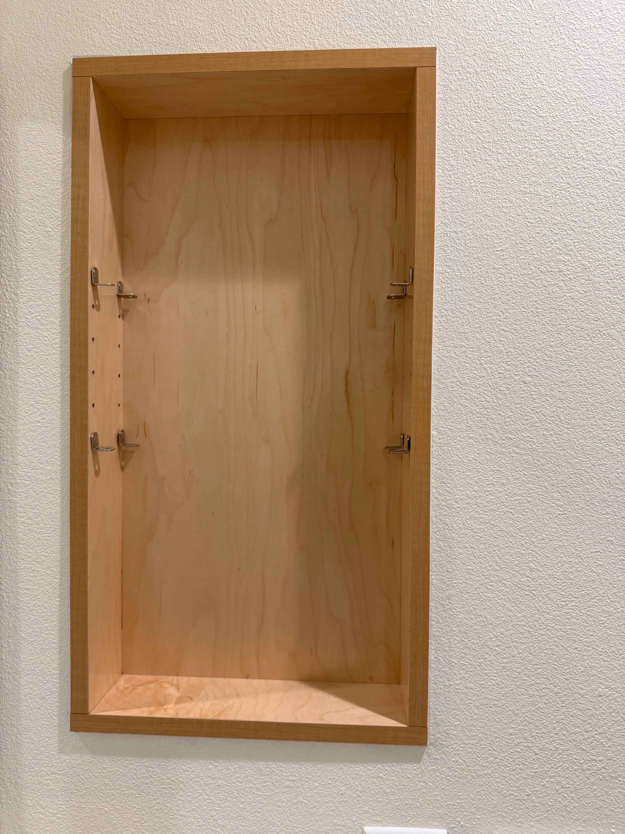 Custom maple recessed vanity cabinet with built-in wood frame and adjustable shelf hardware.