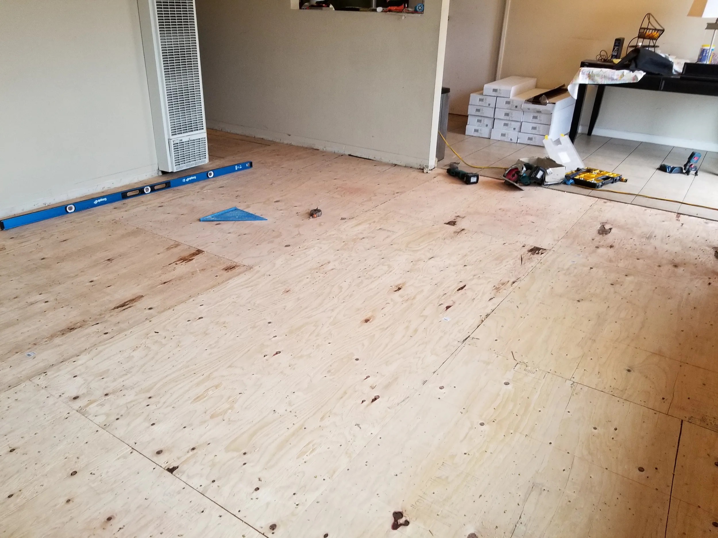 Plywood subfloor preparation for new flooring installation in an interior room.