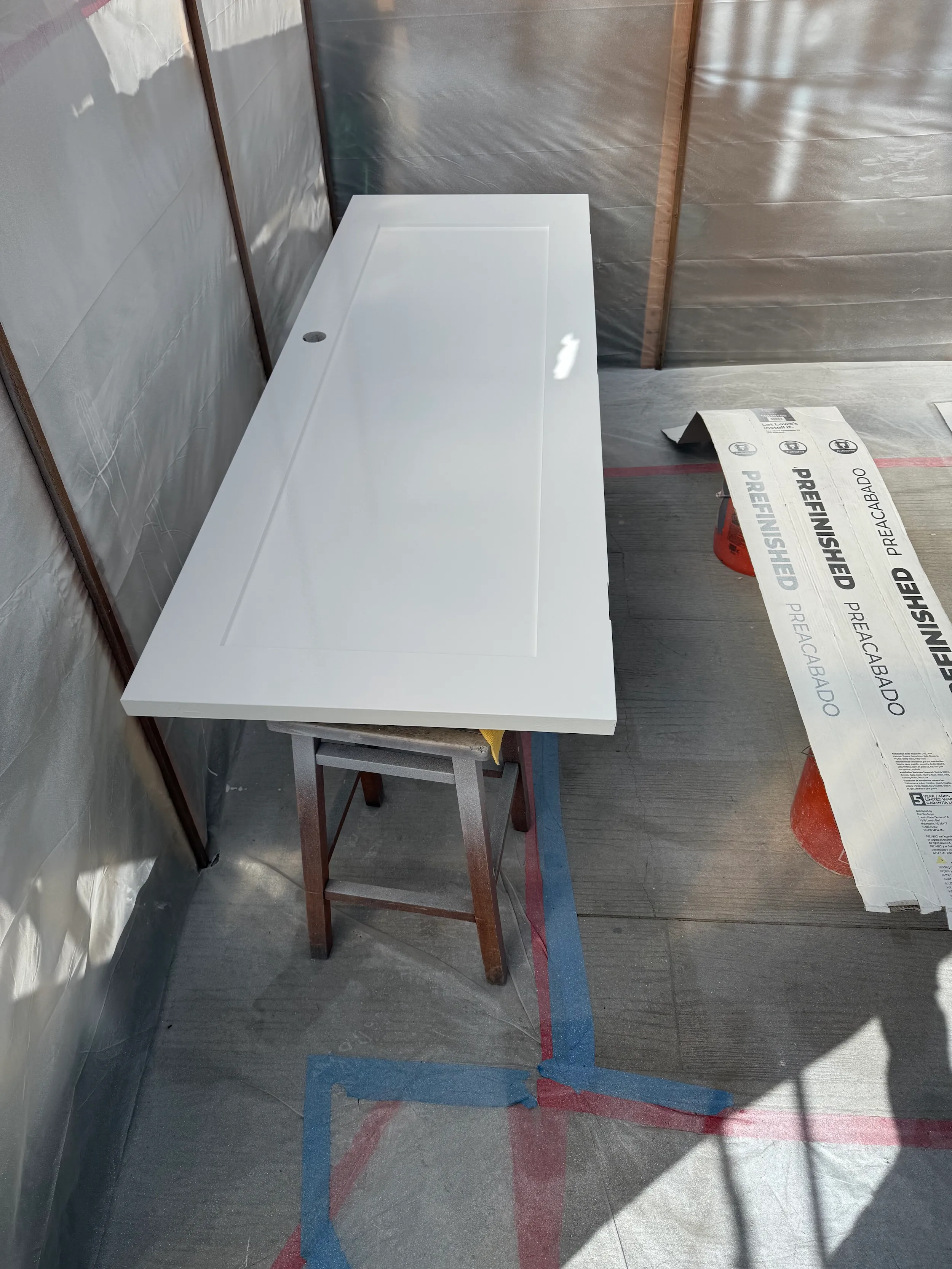 High-end interior door with smooth enamel finish, spray painted using an HVLP system in a controlled setup.
