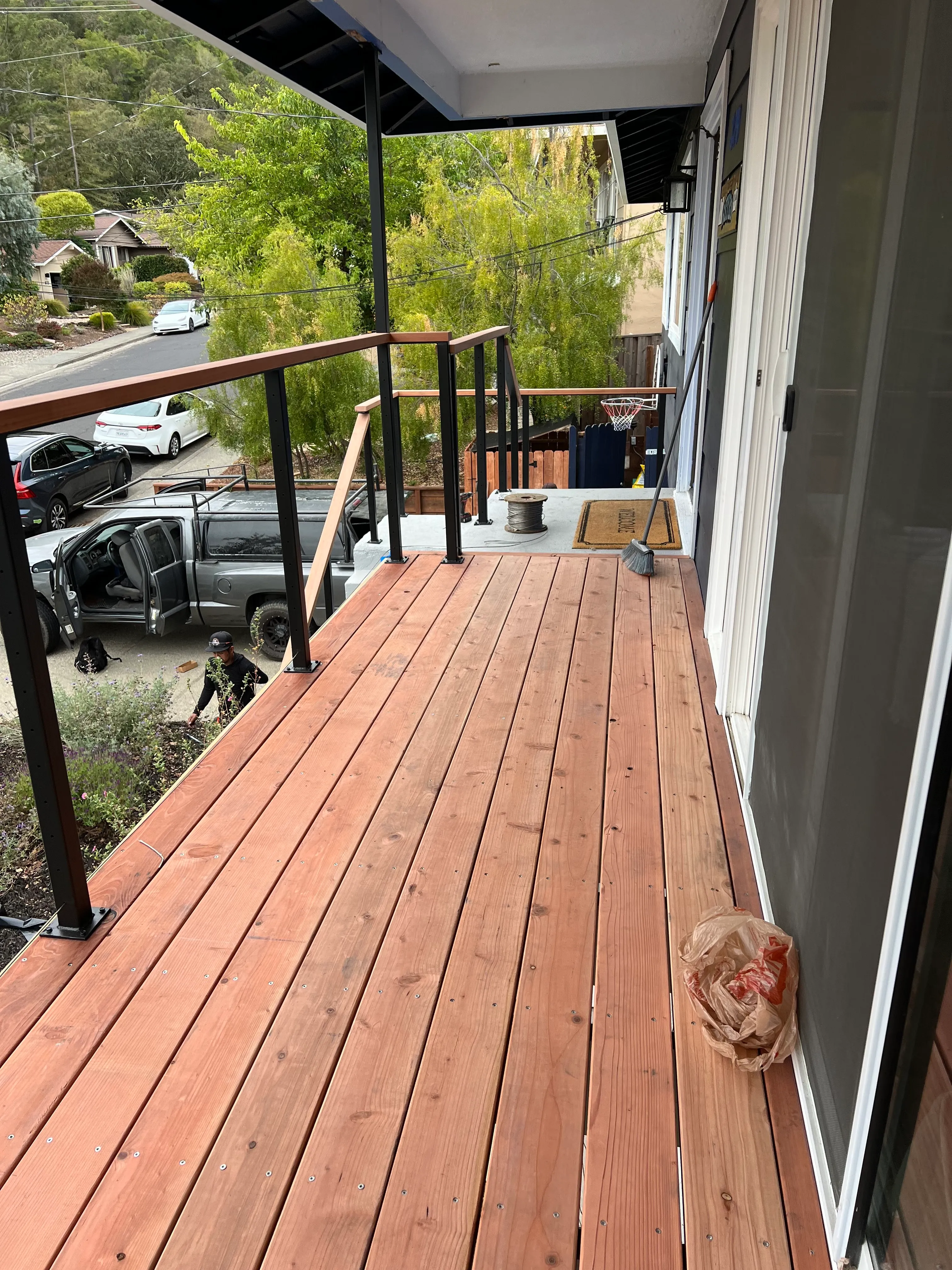Wood deck with exterior railing, black posts, wood handrail, and finished deck boards.