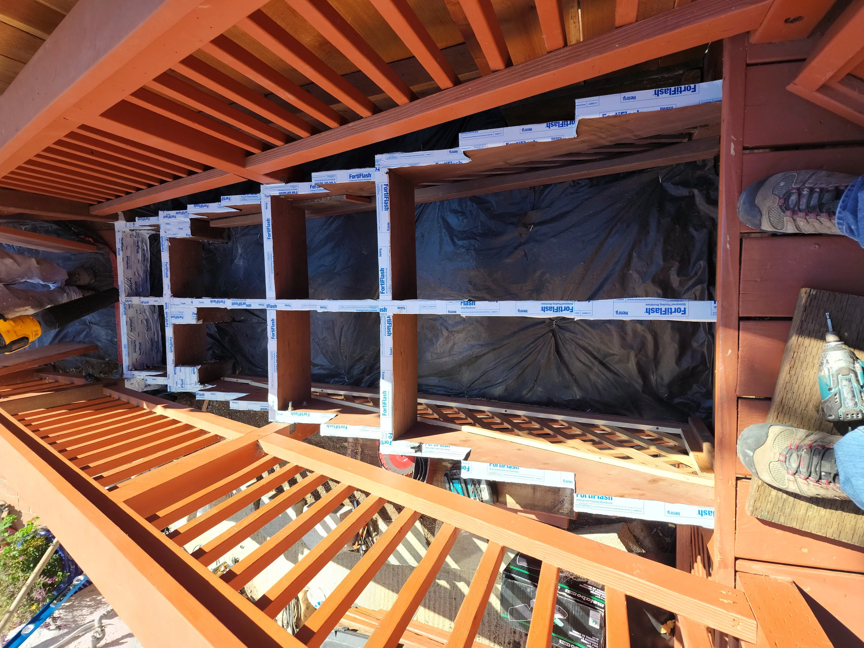 Deck stair replacement in progress with new wood stringers, risers, and stair framing installed.