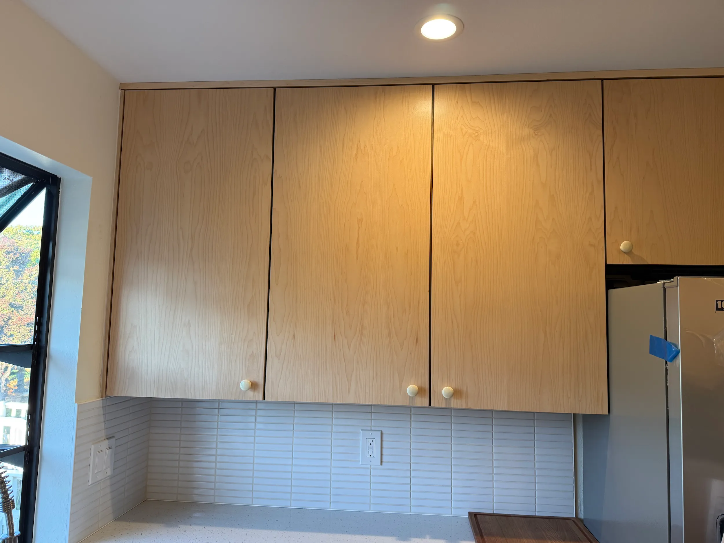 Custom kitchen cabinet panels made in maple wood veneer with a satin clear coat finish.