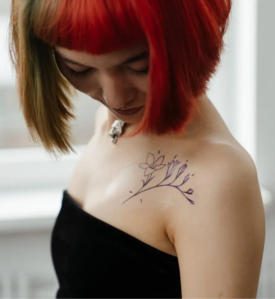 red haired woman in black tube top with silver cross-pendant necklace