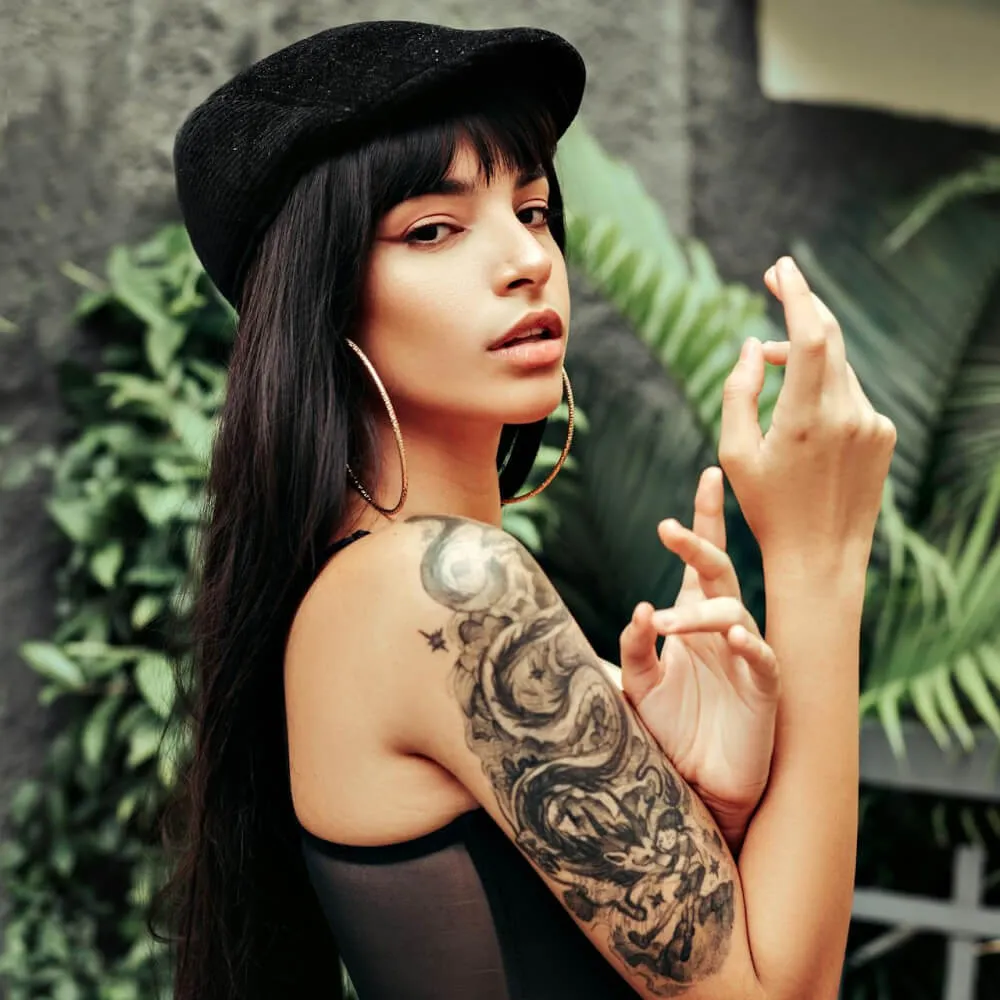 woman in black tank top with black tattoo on her left shoulder