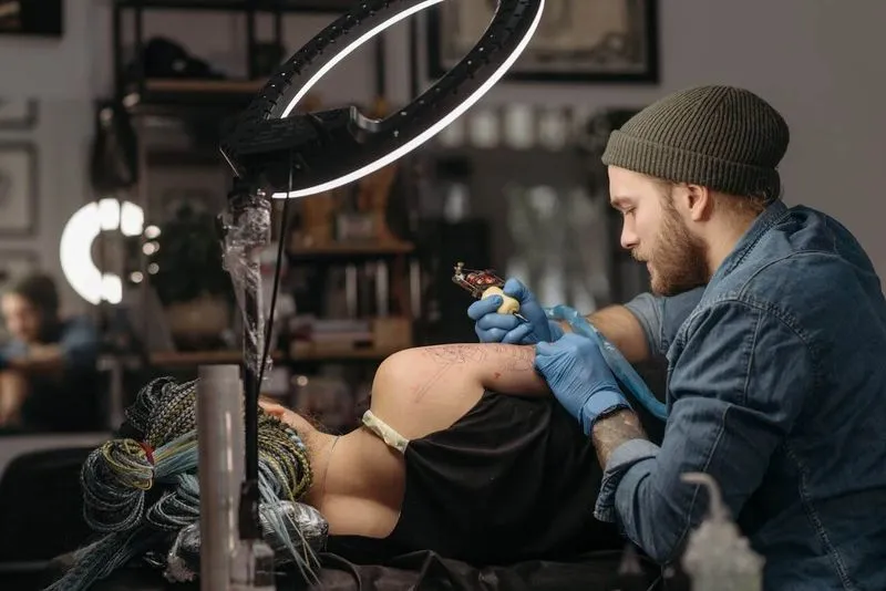 man tattooing a client s arm
