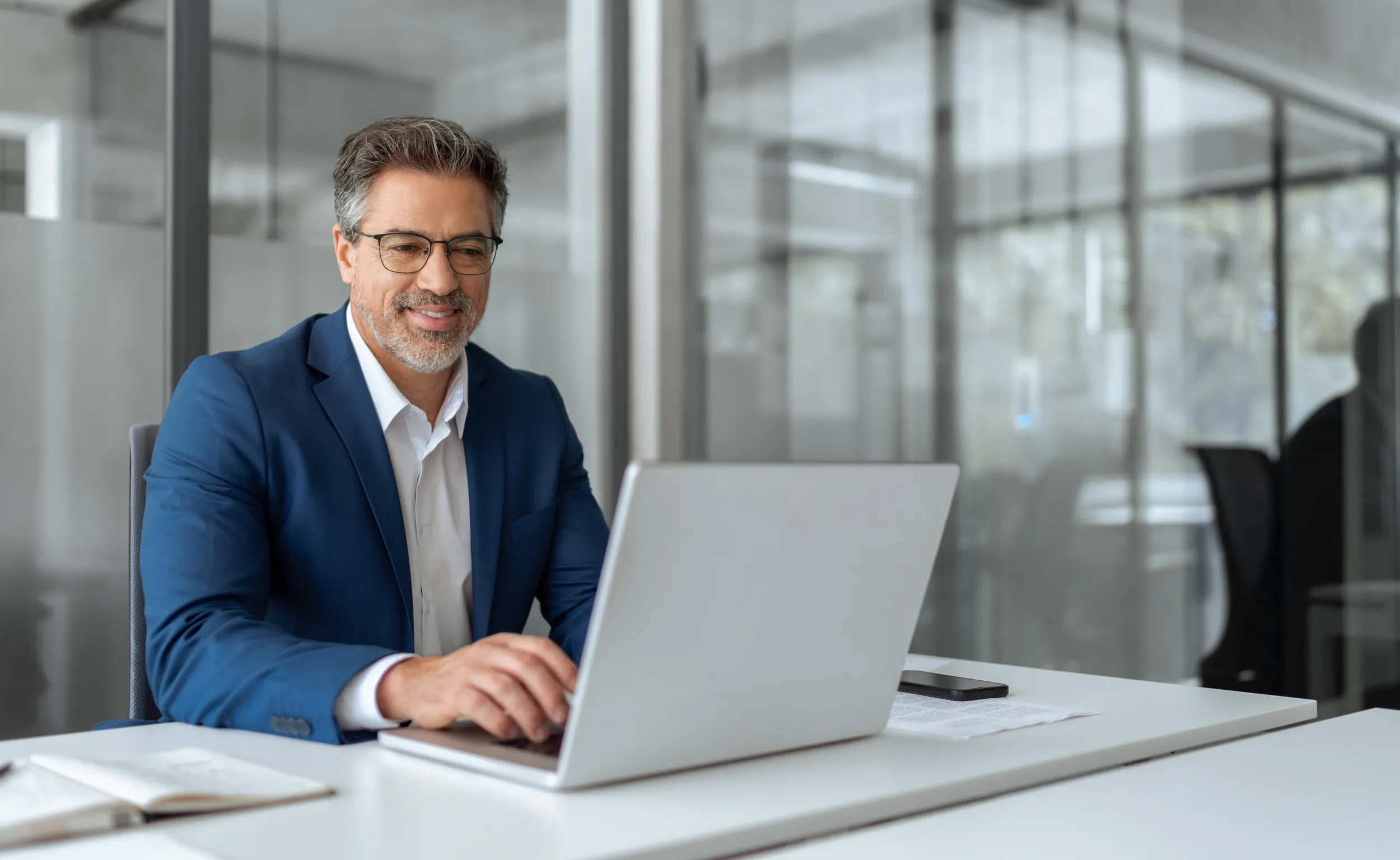 Businessman typing on a laptop while sitting at a desk