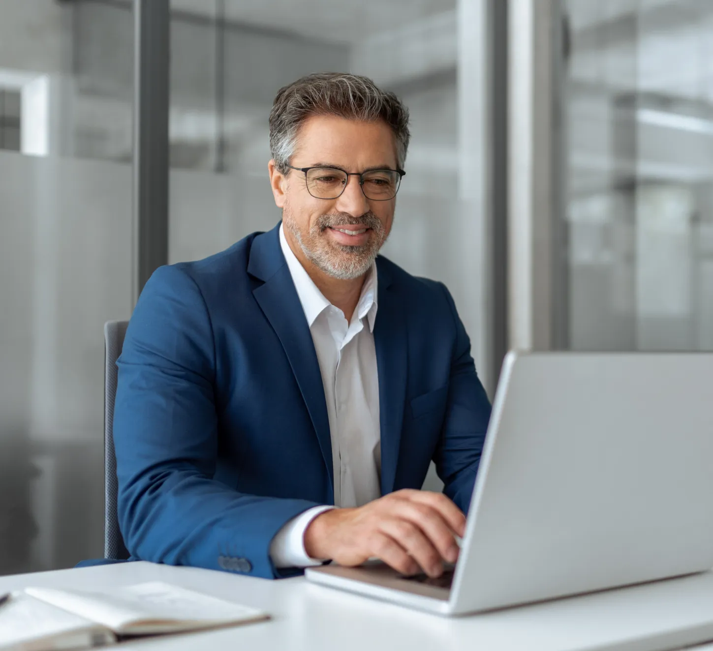 Businessman typing on a laptop while sitting at a desk