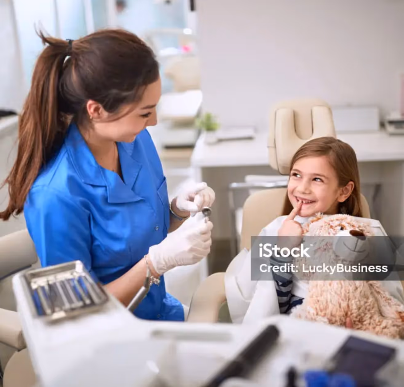 Girl at dentist holding a teddy bear