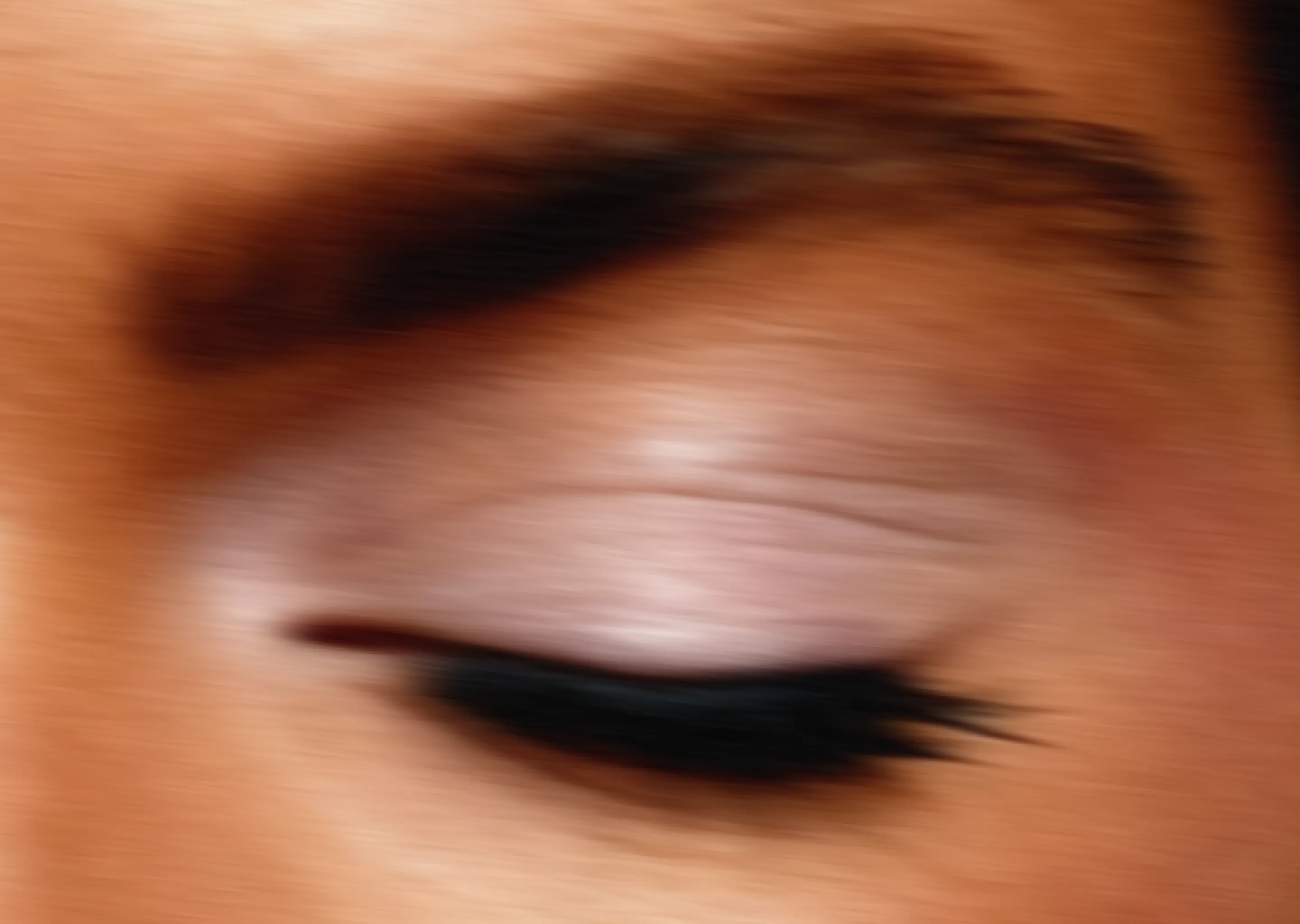 Close-up of a closed eye with shimmery eyeshadow and long black eyelashes.