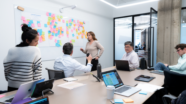 Handpicked Health team members gather around a desk for a brainstorming session