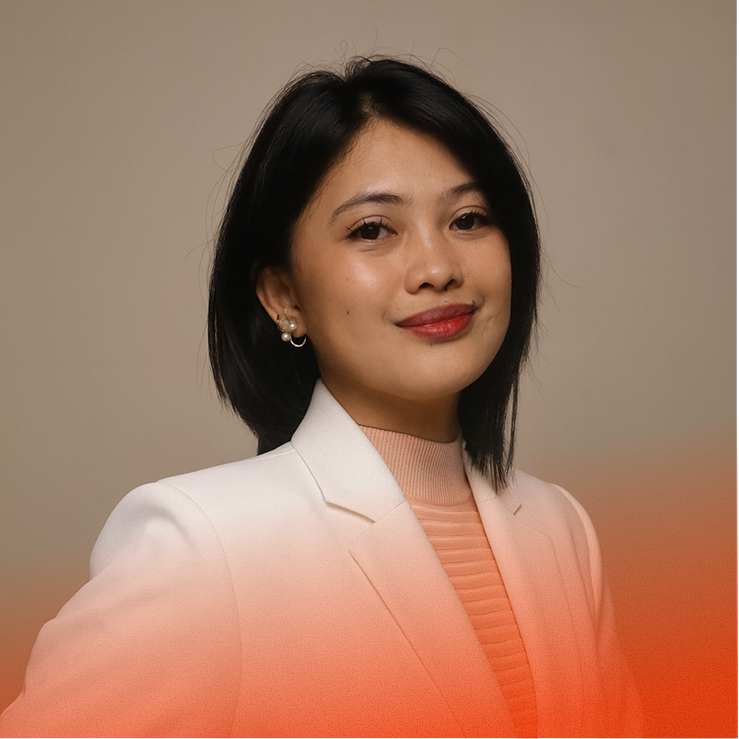 Woman smiles, wearing a white blazer against a neutral studio backdrop.