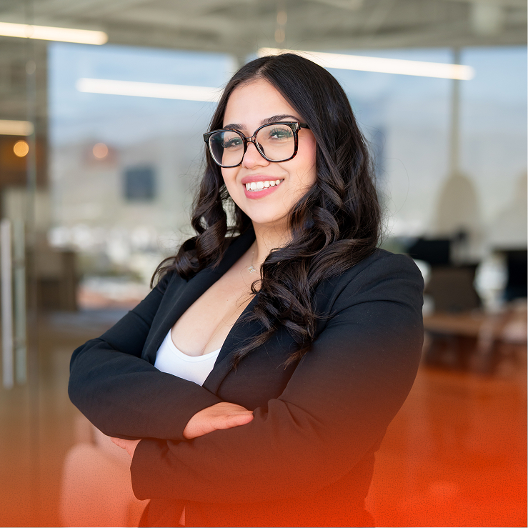 Woman wearing glasses smiling with arms crossed in an office
