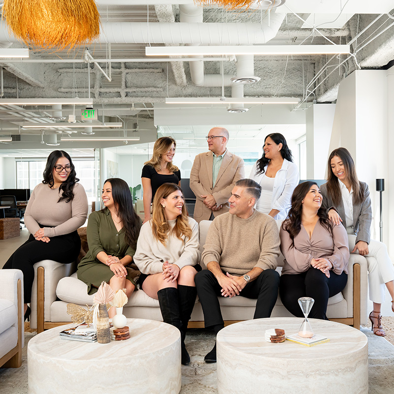 Group of colleagues chatting on couches in a modern office lounge