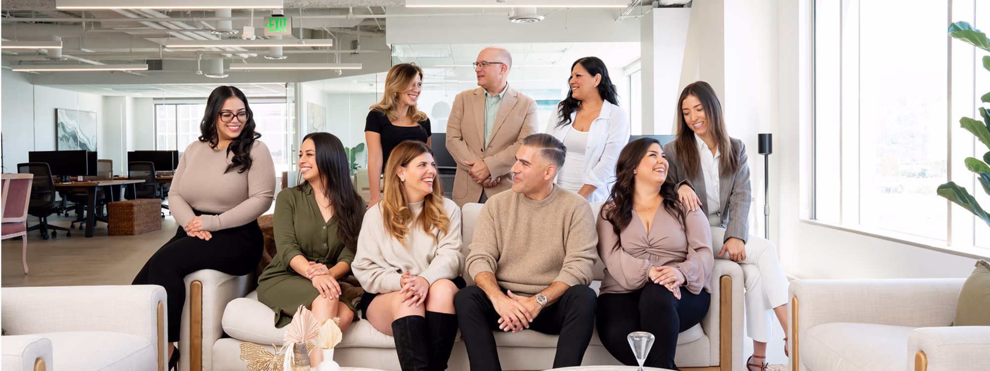 Group of colleagues chatting on couches in a modern office lounge
