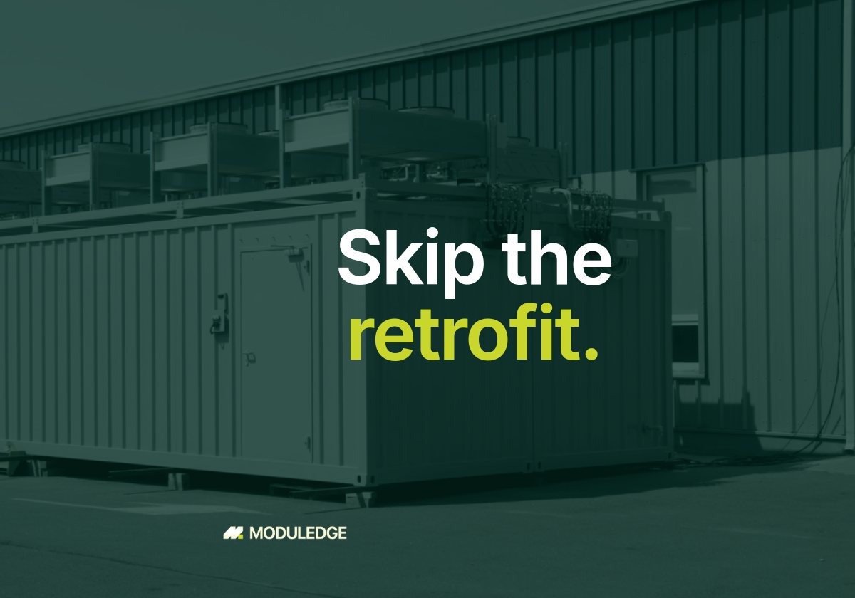 Two white modular data-center containers outside an industrial building, with the headline "Skip the retrofit."