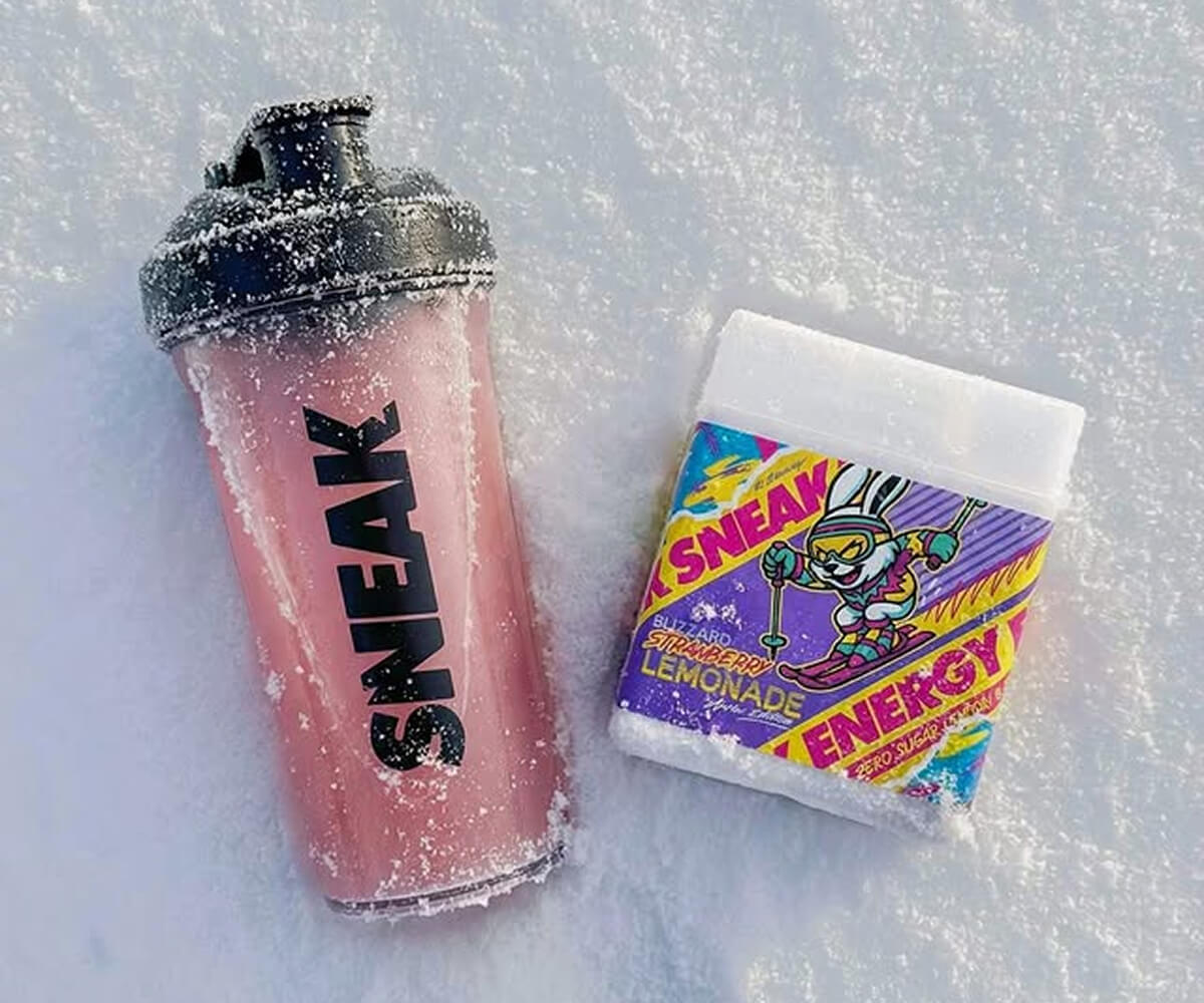 Young man and woman dressed in black and gray carrying matching gray bags with a textured pattern, standing in front of a circular-patterned wall.