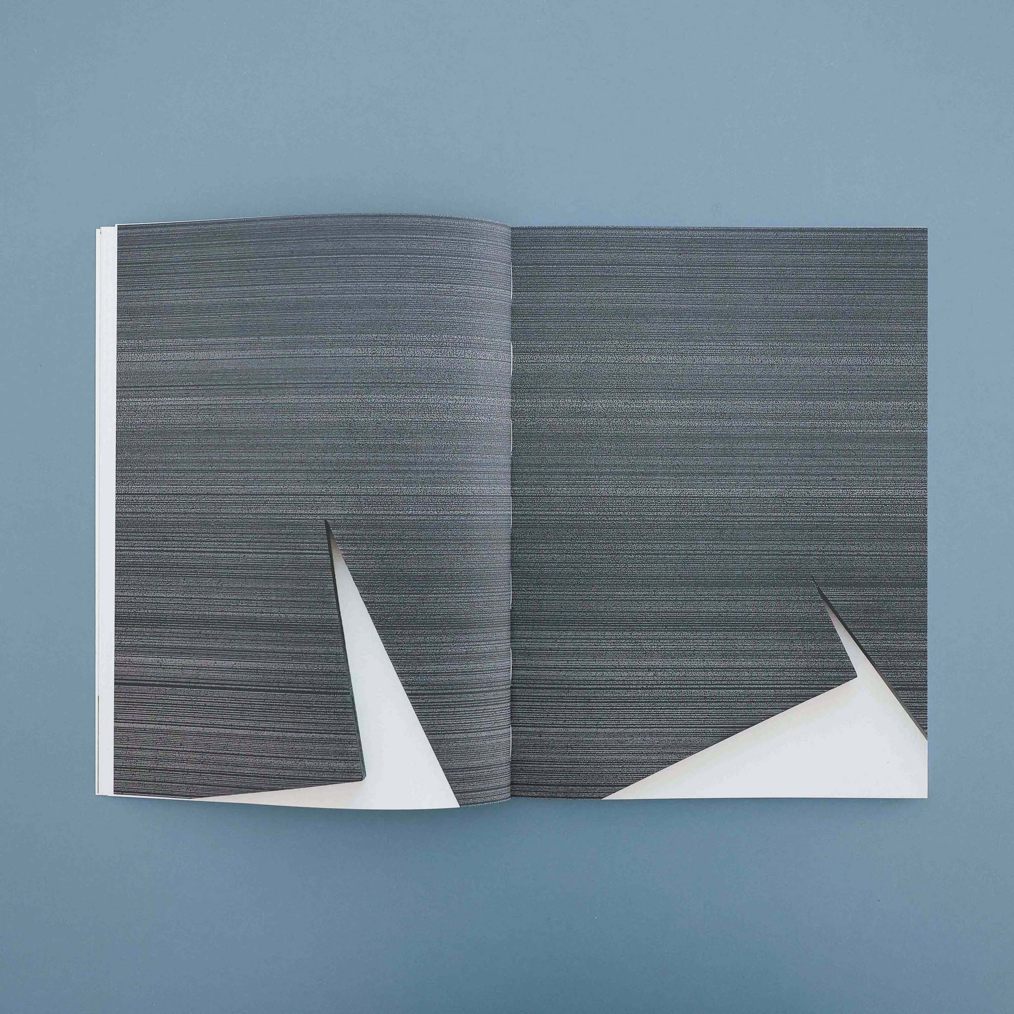 Open book with black pages showing multiple white geometric line designs resembling abstract shapes.