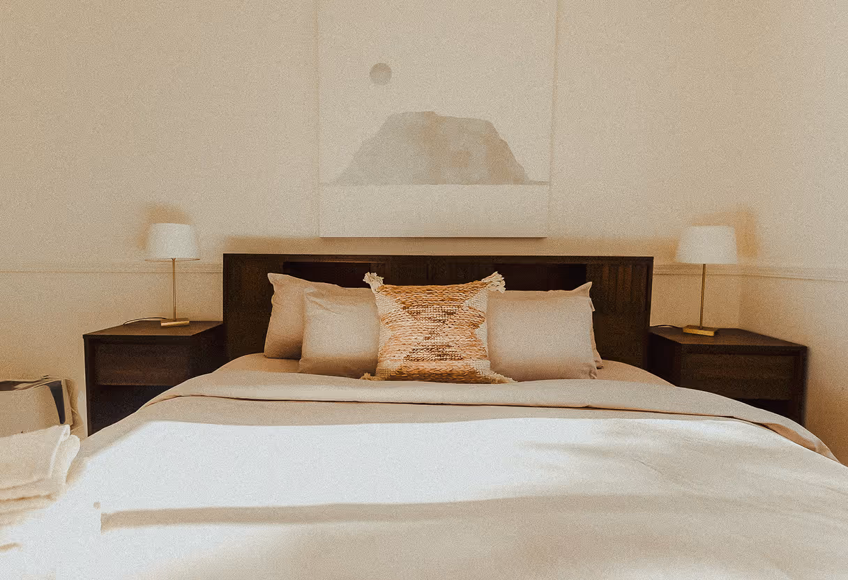 A bed with two nightstands and a painting on the wall.
