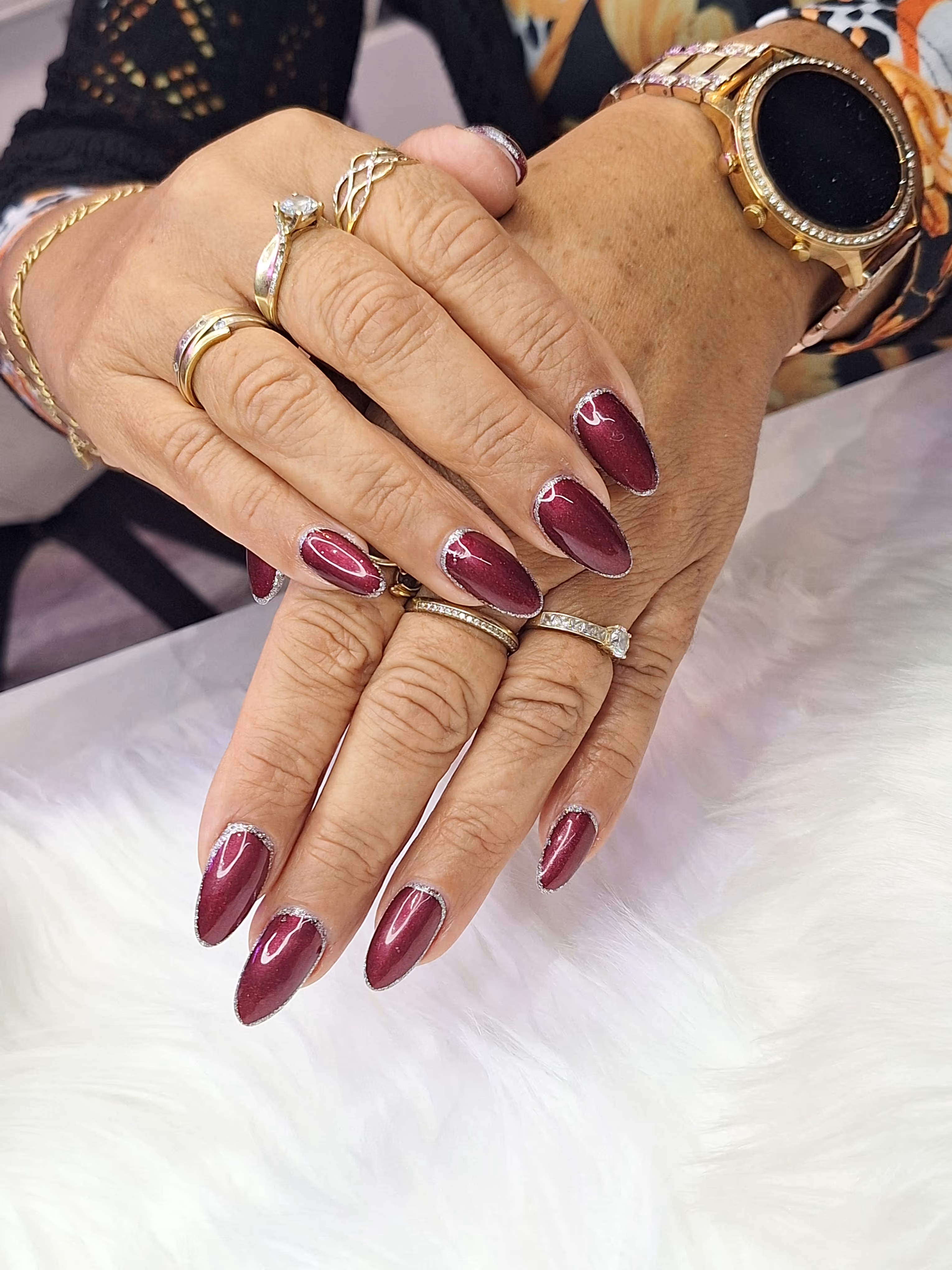 Zwei Hände mit rosa-lila Nageldesign – Maniküre