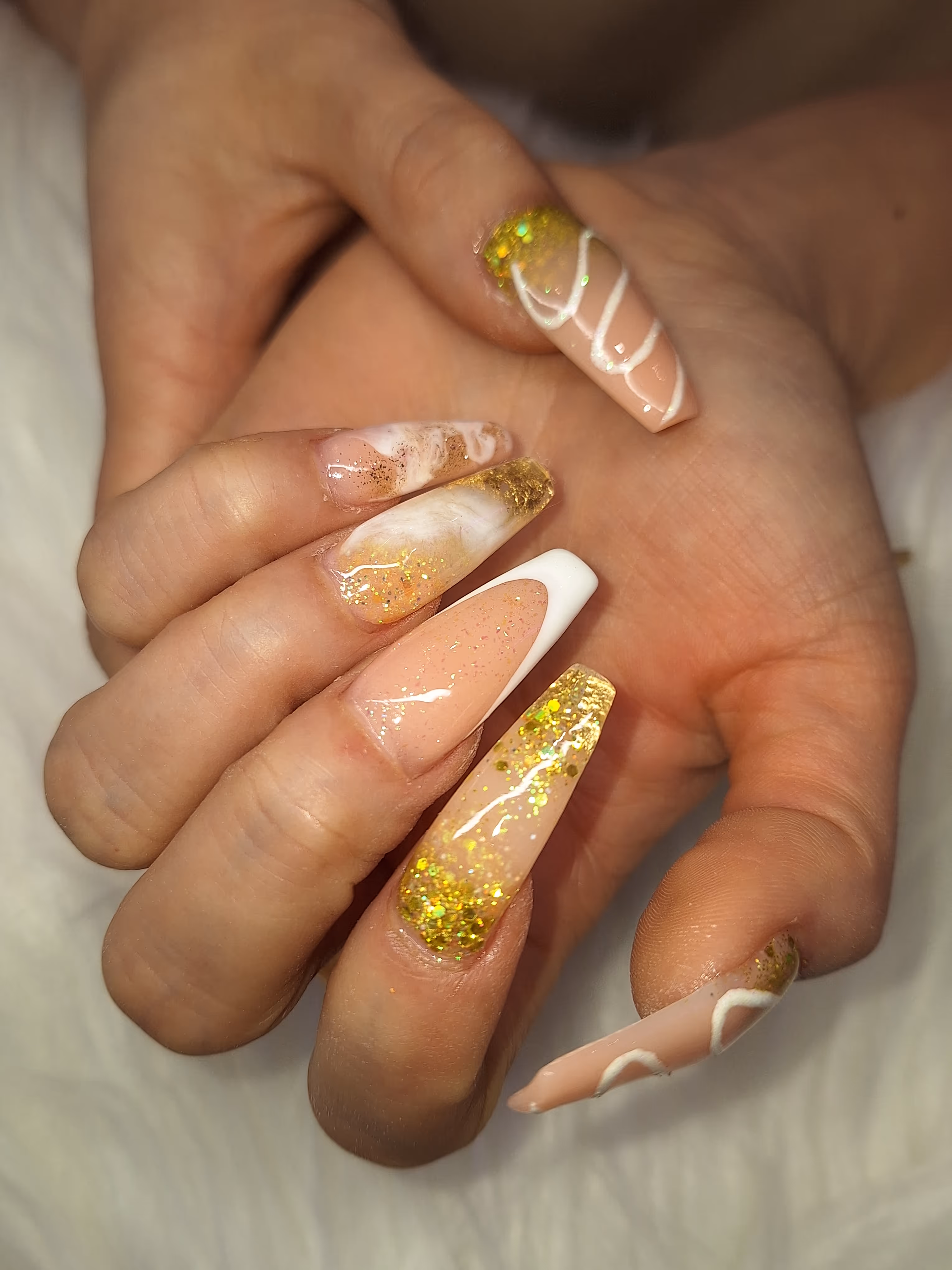 Eine Hand mit weiß-gelbem Nageldesign – Maniküre