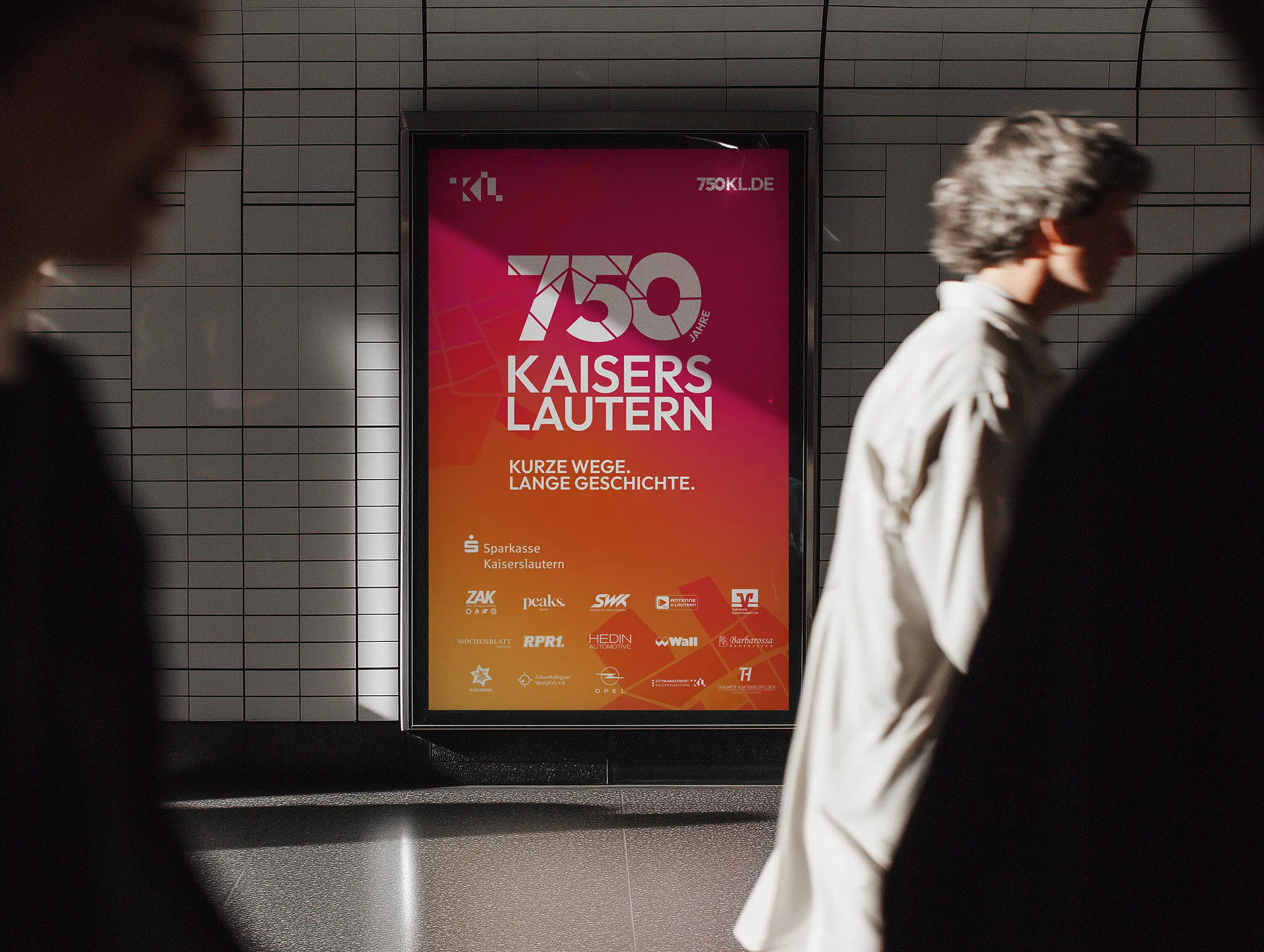Werbeplakat in einem U-Bahnhof mit Text 750 Jahre Kaiserslautern und mehreren Logos von Sponsoren.