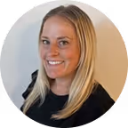 Žena sa plavom kosom i crnom majicom koja se smješi prema kameri.