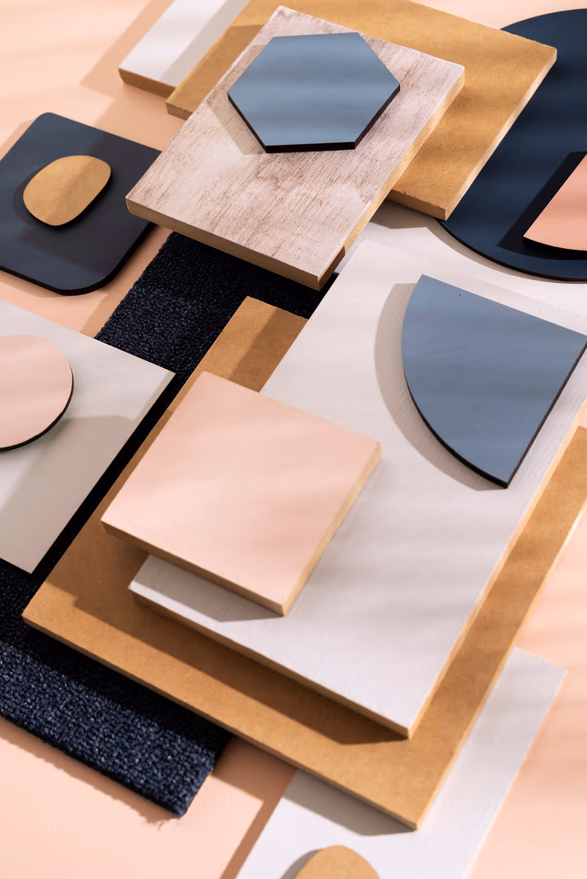 Različiti oblici i materijali u neutralnim tonovima složeni u apstraktni geometrijski uzorak.