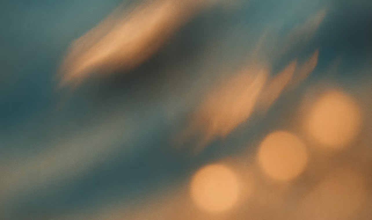 Blå og orange sløret abstrakt baggrund med cirkulære lyspletter.