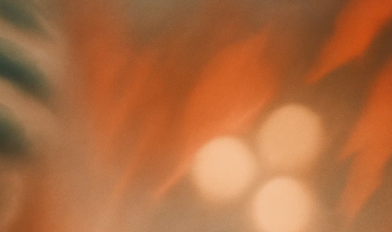 Sløret billede med orange og beige toner samt tre uskarpe lyspletter.