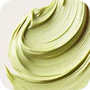 Close-up of smooth, creamy light green paint or cosmetic cream texture with visible brush strokes.