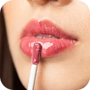 Close-up of lips applying pink lip gloss with a wand applicator.