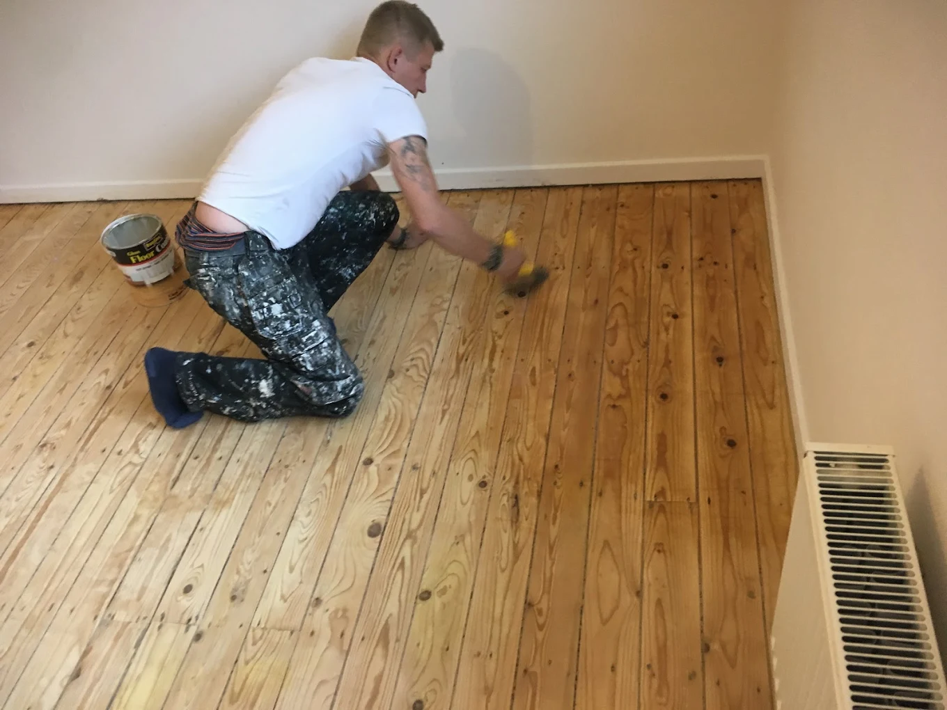 An LD Sussex Decoration team member applying oil to a recently sanded floor at a residential customer's property