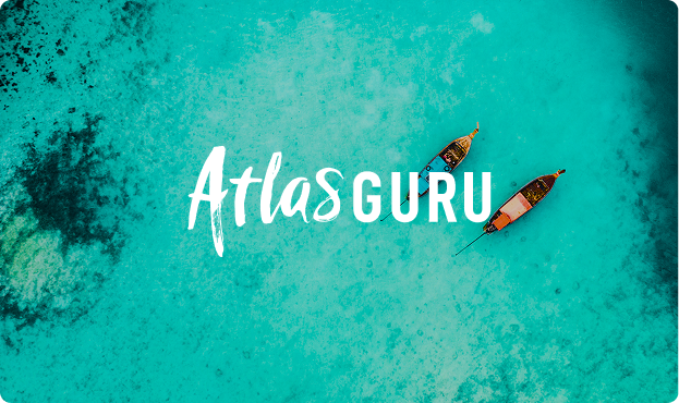 Two boats floating on clear turquoise water with the text 'Atlas GURU' overlayed.