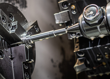 Close-up of a precision machine tool performing metal machining on a cylindrical workpiece.