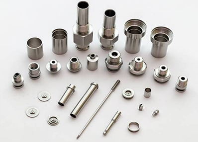 Various stainless steel precision metal parts and fittings arranged in rows on a white background.