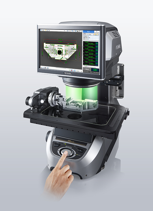 Precision measurement device with a hand pressing a button, displaying a 3D part analysis on the screen.