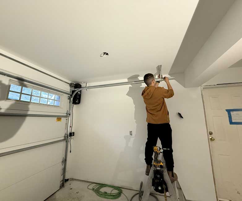 Alex Camino installing a garage door rail.