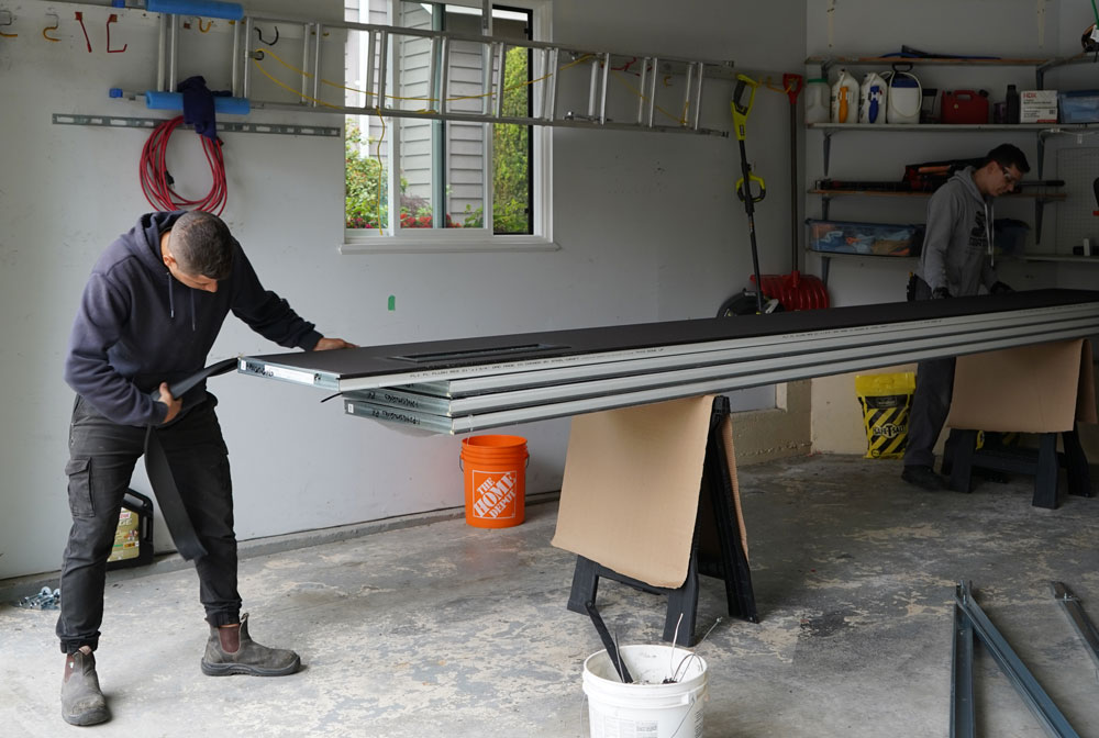 Alex and employee installing a garage door.