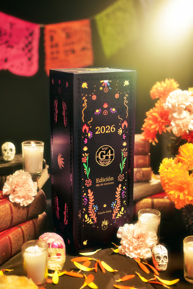 G4 Día de Muertos bottle among candles and papel picado