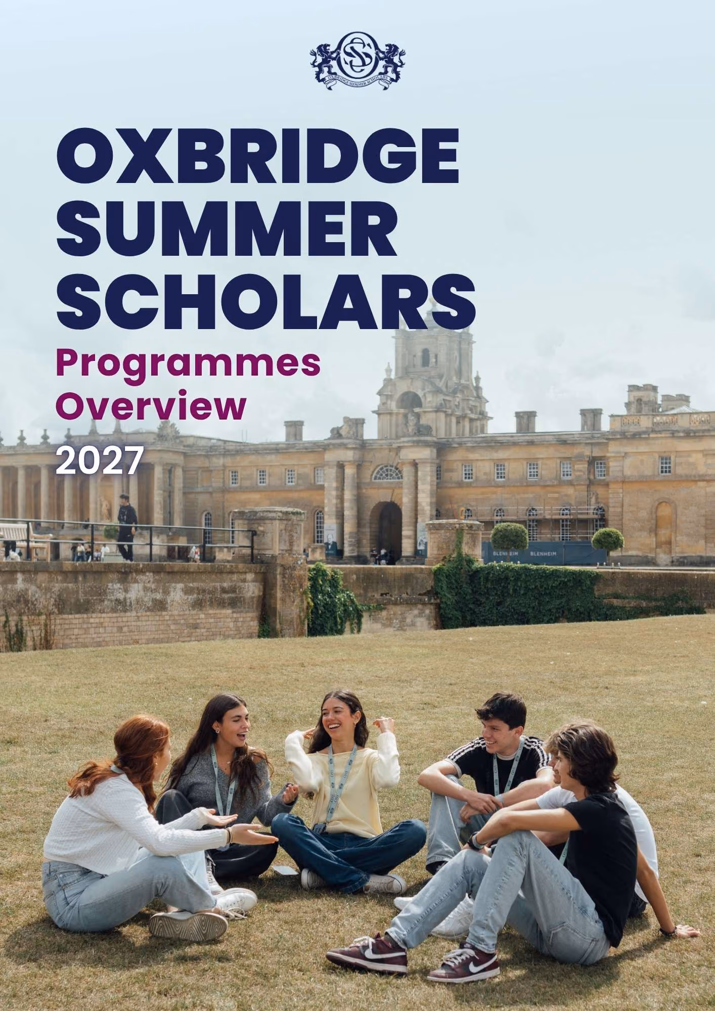 Five young people sitting on grass outside historic Oxford-style building, talking and smiling.